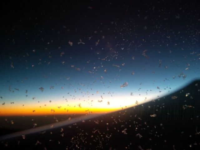 I flew east, left in the evening, flew through the day. This is a sunrise somewhere over Europe, viewed through an ice-crystal-covered window.